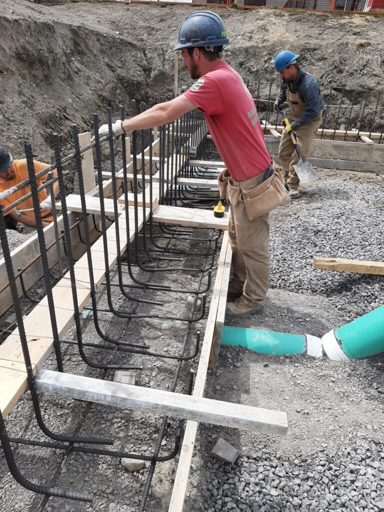 Compacted crushed stone base with rebar laid out before a concrete pour